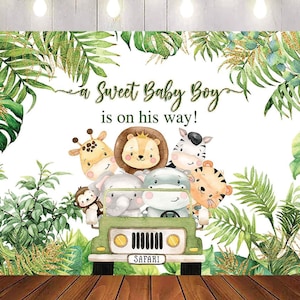 May include: A white backdrop with green foliage and a safari jeep with animal characters. The text reads "A Sweet Baby Boy is on his way!"