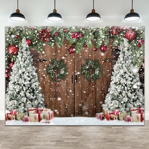 May include: A Christmas backdrop featuring a rustic wooden barn door with two snow-covered Christmas trees on either side. The door is decorated with wreaths and red ornaments. The trees are adorned with lights and red and gold gift boxes.