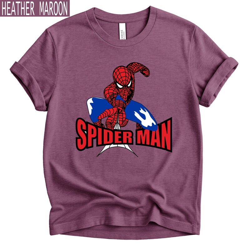 Op de afbeelding: Heather maroon t-shirt met een rood en blauw Spider-Man-ontwerp en de tekst "SPIDER MAN" in het rood. Het shirt heeft opgerolde mouwen en een ronde hals. De tekst "HEATHER MAROON" staat bovenaan.