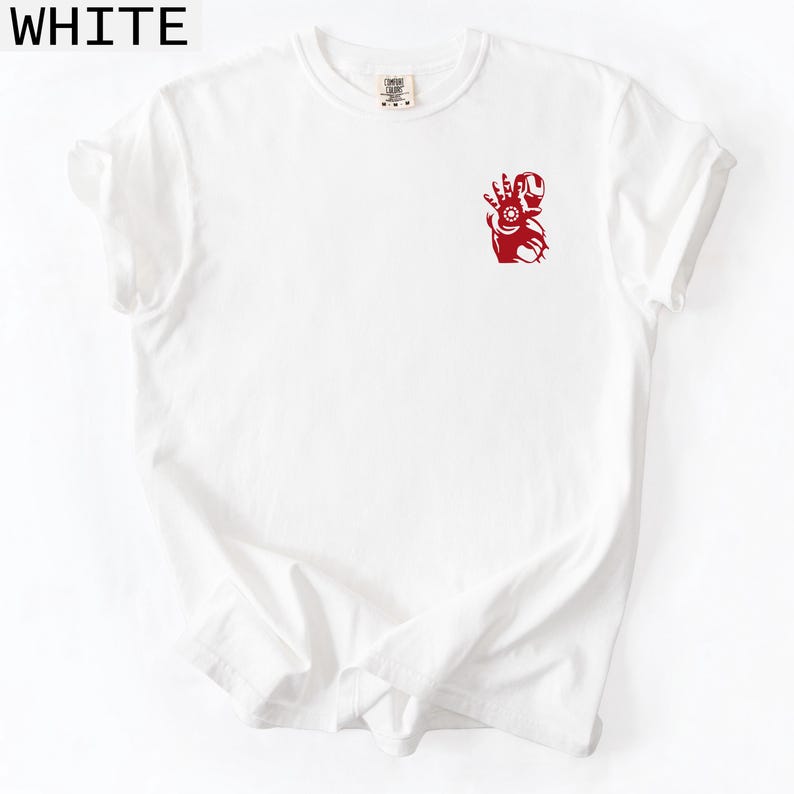 Puede incluir: Una camiseta blanca de manga corta con un peque&ntilde;o gr&aacute;fico rojo en la parte superior izquierda del pecho. El gr&aacute;fico muestra una ilustraci&oacute;n estilizada de una mano rob&oacute;tica con la palma abierta y un detalle circular en el centro. Cuello redondo.