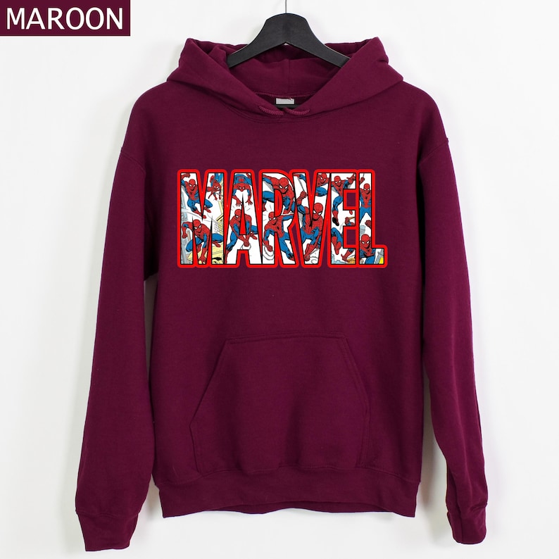 Puede incluir: Sudadera con capucha de color granate con la palabra "MARVEL" en letras con contorno rojo. Las letras est&aacute;n rellenas de im&aacute;genes de Spider-Man. La sudadera tiene un bolsillo delantero y una capucha con cord&oacute;n.
