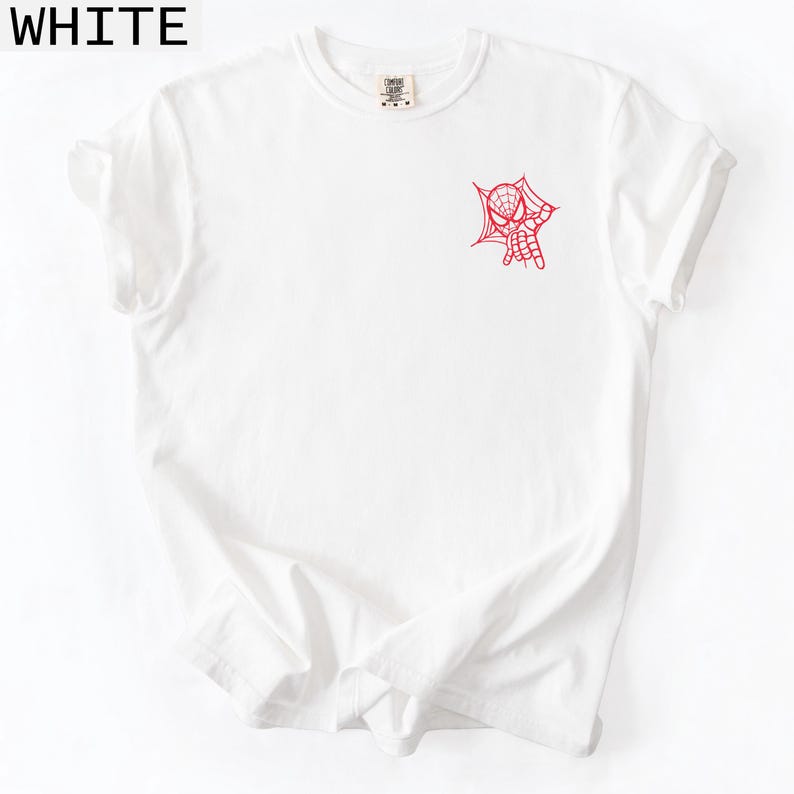 K&ouml;nnte beinhalten: Wei&szlig;es T-Shirt mit rotem Spider-Man-Netz- und Handdesign auf der Vorderseite. Das Wort "WHITE" befindet sich in der oberen linken Ecke. Das Shirt hat einen Rundhalsausschnitt und kurze &Auml;rmel.