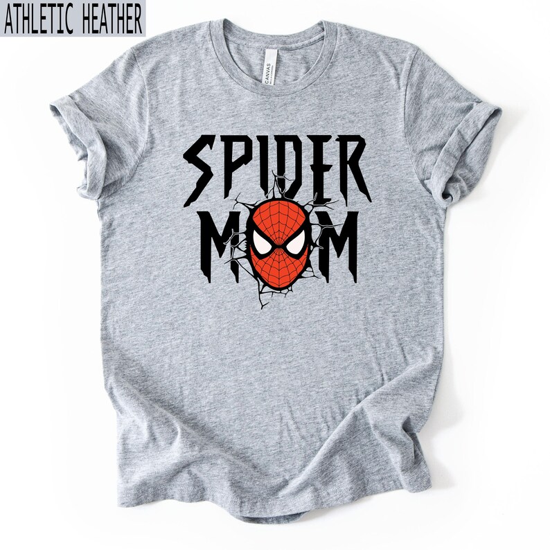 May include: Grey t-shirt with the text "SPIDER MOM" in black, featuring a red and white Spider-Man mask graphic. The shirt is made of a soft material and has a crew neck.