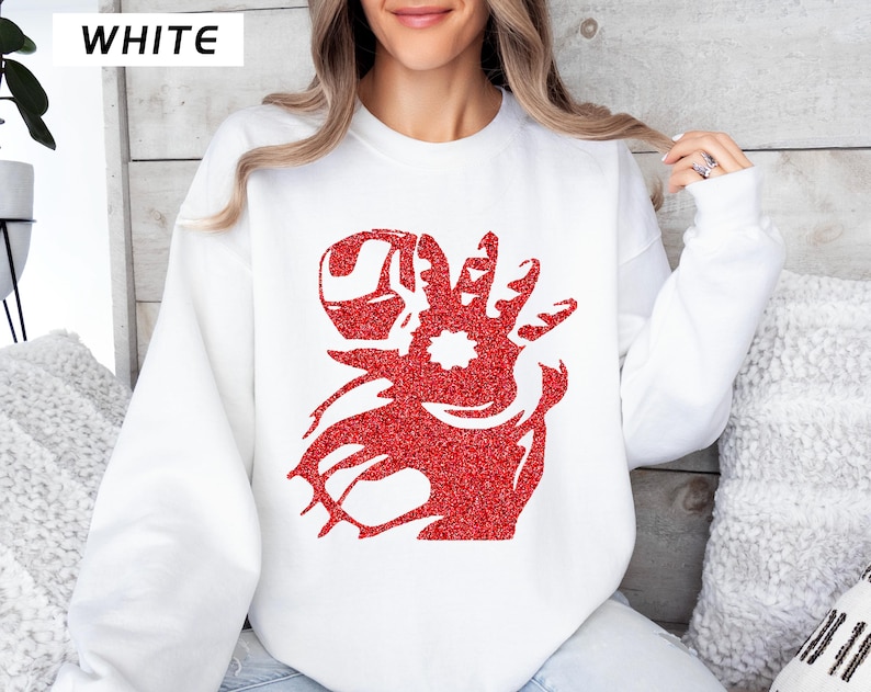 May include: White sweatshirt with a red glitter graphic of a superhero's hand. The word "WHITE" is printed in black in the upper left corner. The sweatshirt is a crew neck style and is being worn by a person.