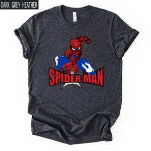 Op de afbeelding: Donkergrijze heather t-shirt met een rood en blauw Spider-Man-ontwerp. De superheld wordt afgebeeld in een dynamische pose met de woorden "SPIDER MAN" in het rood. Het shirt heeft korte mouwen en een ronde hals.