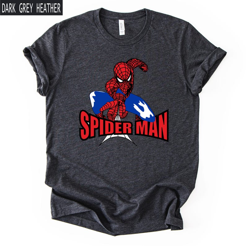 Op de afbeelding: Donkergrijze heather t-shirt met een rood en blauw Spider-Man-ontwerp. De superheld wordt afgebeeld in een dynamische pose met de woorden "SPIDER MAN" in het rood. Het shirt heeft korte mouwen en een ronde hals.