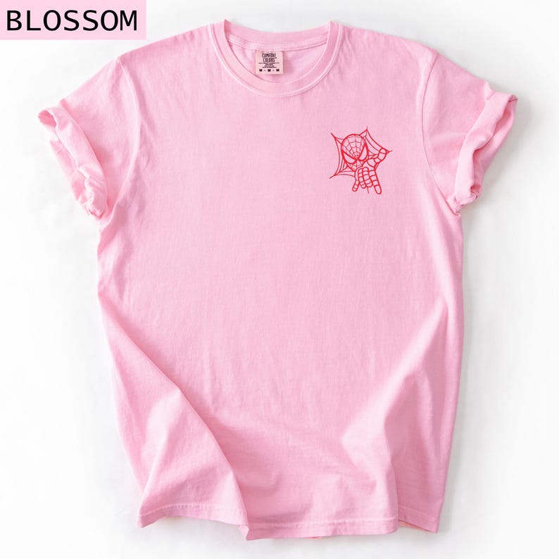 K&ouml;nnte beinhalten: Hellrosa T-Shirt mit hochgekrempelten &Auml;rmeln. Auf der Vorderseite ist eine rote Spider-Man-Grafik aufgedruckt. Das Wort "BLOSSOM" befindet sich oben links. Das Shirt besteht aus einem weichen Material.