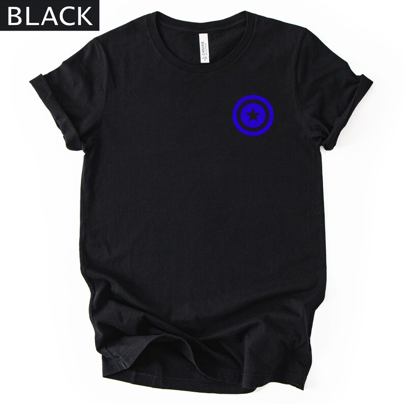Pu&ograve; includere: T-shirt nera con un design grafico blu e nero sul davanti. La grafica &egrave; un cerchio blu con una stella blu al centro. La parola "BLACK" &egrave; in testo bianco nell'angolo in alto a sinistra.