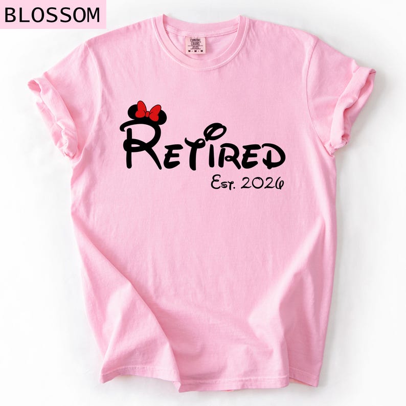 Puede incluir: Camiseta rosa claro con la palabra "Retired" en una fuente caprichosa, con un lazo de Minnie Mouse. El texto "Est. 2026" est&aacute; debajo. La palabra "Blossom" est&aacute; en la esquina superior izquierda.