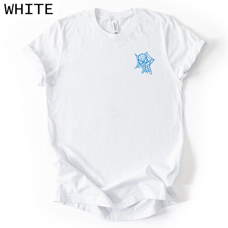 Op de afbeelding: Een wit T-shirt met korte mouwen en een kleine blauwe afbeelding op de linkerborst. De afbeelding toont het hoofd van een spinnenfiguur dat uit een webontwerp tevoorschijn komt. Het T-shirt heeft een ronde hals en een standaard pasvorm.