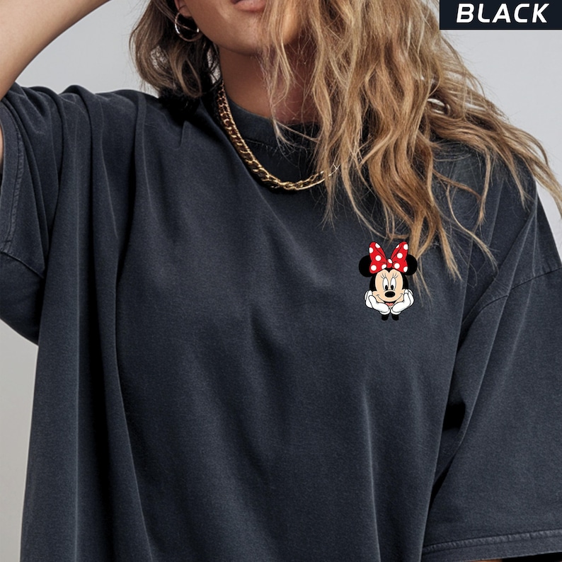 May include: Black oversized t-shirt with a small Minnie Mouse graphic on the front. The graphic shows Minnie Mouse with a red bow with white polka dots. The word "BLACK" is printed in white at the top.