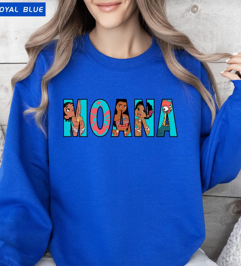 May include: Royal blue sweatshirt with the word "MOANA" in a colourful design. The letters are filled with cartoon images of characters from the film. The sweatshirt is a crew neck style.