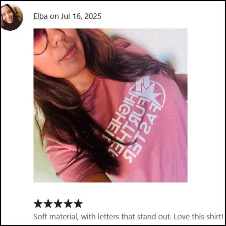 May include: A pink t-shirt featuring the white text "HIGHER FURTHER FASTER" and a star design. The shirt is made of a soft material.