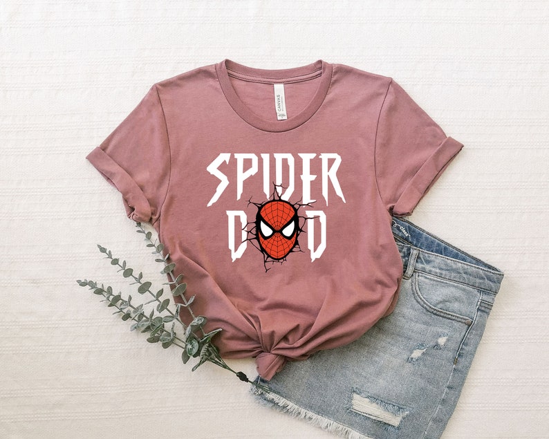 K&ouml;nnte beinhalten: Ein mauvefarbenes T-Shirt mit einer wei&szlig;en Grafik eines Spider-Man-Gesichts und dem Text "SPIDER DAD".