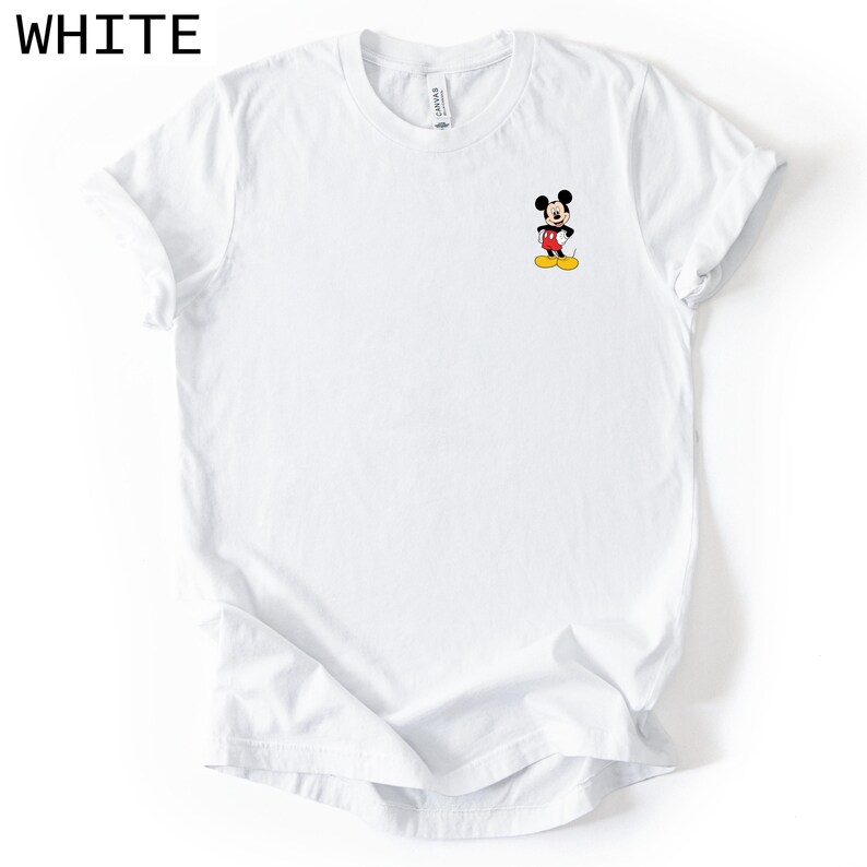 May include: A white short-sleeved t-shirt featuring a small graphic of Mickey Mouse on the left chest area. The character is depicted in his classic black, red, and yellow colours. The shirt has a crew neckline and a standard fit design.