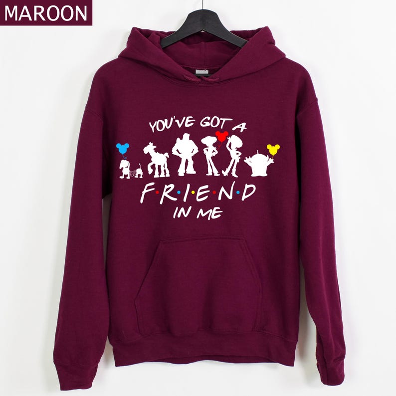 Puede incluir: Sudadera con capucha color granate con un gr&aacute;fico blanco que presenta personajes y el texto "YOU'VE GOT A FRIEND IN ME". El dise&ntilde;o incluye acentos coloridos. La sudadera tiene un bolsillo delantero y una capucha con cord&oacute;n.