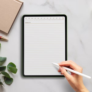 May include: A digital tablet with a green border shows a lined page with the date "January 1st" at the top. A white stylus is held by a person's hand, ready to write. A brown notebook and pen are visible in the background.