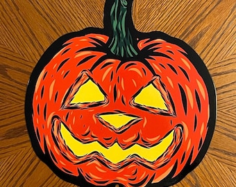 May include: A red and black Halloween pumpkin with a carved face and yellow teeth. The pumpkin has a green stem.