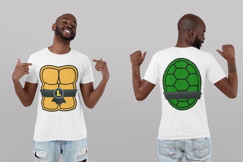 May include: White t-shirt featuring a cartoon design of a turtle shell on the front and back. The front design is yellow with a black belt and the letter "L". The back design is green with a black belt.