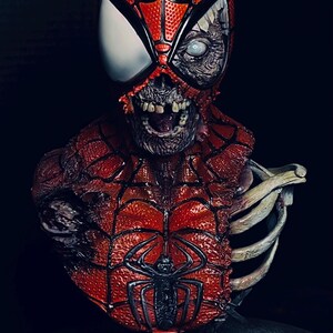 May include: A red and black zombie Spider-Man bust with a skeletal ribcage. The bust is on a black base with skulls and the text "MARVEL ZOMBIES R.I.P."