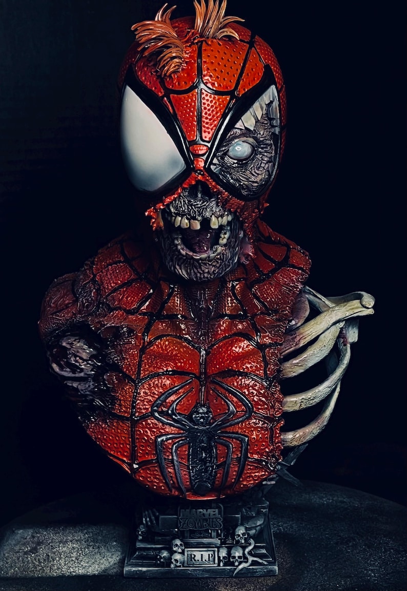 May include: A red and black zombie Spider-Man bust with a skeletal ribcage. The bust is on a black base with skulls and the text "MARVEL ZOMBIES R.I.P."