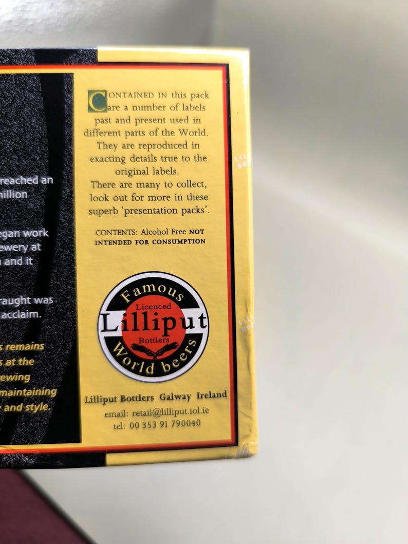 May include: A portion of a box with text and a circular logo. The logo reads "Famous Lilliput World beers." Text on the box states the pack contains labels from around the world, reproduced in detail. The text also states the contents are alcohol-free.