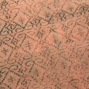 May include: Close-up of a pink and black patterned fabric with a woven texture.