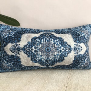 Op de afbeelding: Rechthoekig decoratief kussen met een blauw-wit bloemmotief. Het kussen heeft een centraal medaillonontwerp in blauw- en grijstinten, met een lichtgrijze achtergrond. De randen zijn donkerblauw.