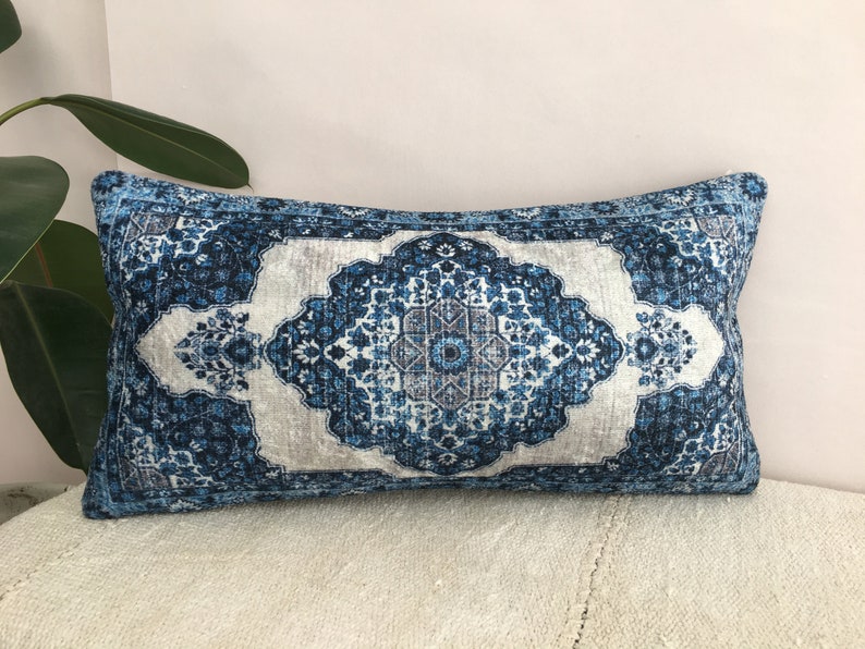Op de afbeelding: Rechthoekig decoratief kussen met een blauw-wit bloemmotief. Het kussen heeft een centraal medaillonontwerp in blauw- en grijstinten, met een lichtgrijze achtergrond. De randen zijn donkerblauw.