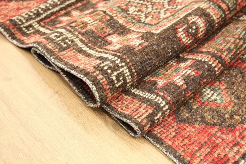 A close-up view of a colorful, intricately patterned rug on a wooden surface.