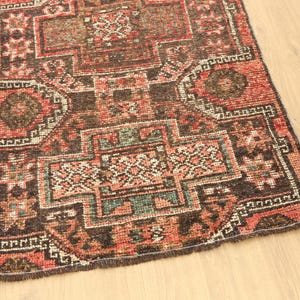 a colorful, intricately patterned rug or carpet placed on a wooden floor.