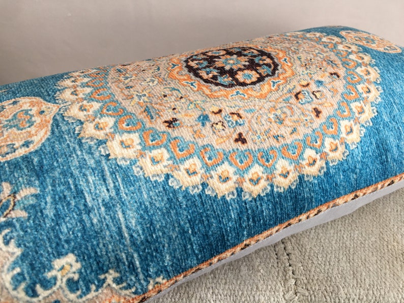 May include: A blue and orange patterned throw pillow with a decorative design. The pillow is made of a soft, plush fabric and has a subtle sheen.