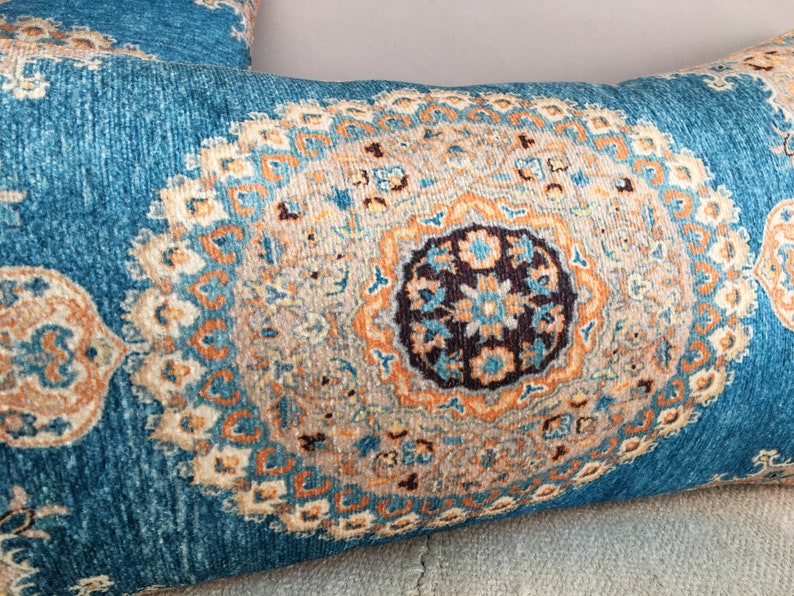 May include: A blue and orange patterned throw pillow with a large, intricate design in the center.