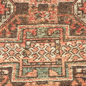 The image is a close-up of a colorful, intricately patterned rug or carpet with a variety of geometric shapes and designs.