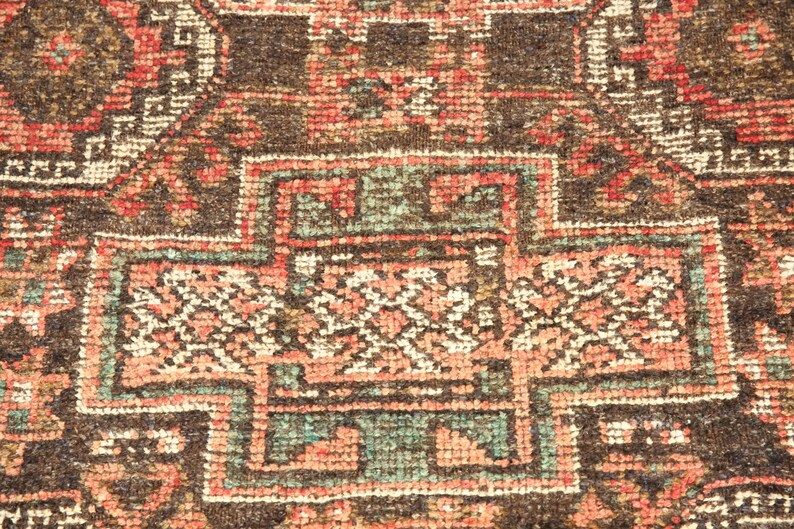 The image is a close-up of a colorful, intricately patterned rug or carpet with a variety of geometric shapes and designs.