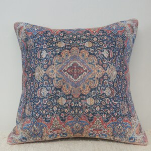 May include: A decorative throw pillow with a blue, red, and gold patterned design. The pattern is intricate and features a floral motif.