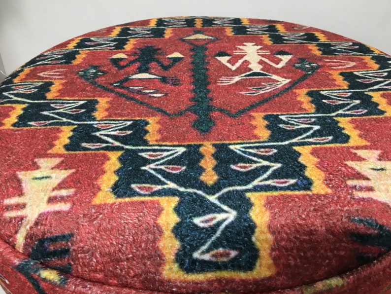 Puede incluir: Otomana redonda con estampado geom&eacute;trico en rojo, amarillo, negro y blanco.