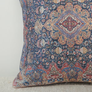 May include: A blue throw pillow with a colorful paisley pattern. The pillow has a red, yellow, and blue design.