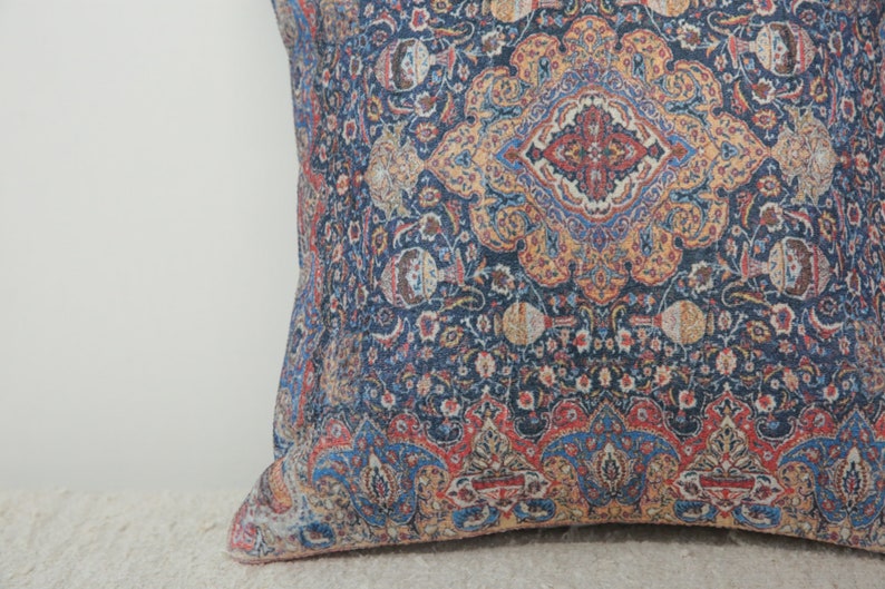 May include: A blue throw pillow with a colorful paisley pattern. The pillow has a red, yellow, and blue design.