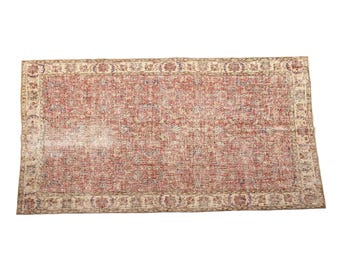 May include: A rectangular area rug featuring a central field of muted red with intricate floral and vine patterns in shades of blue and cream. The rug is framed by a wide, decorative border in cream, red, and blue with repeating floral motifs.
