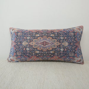 May include: A decorative pillow with a blue, red, and orange patterned design. The pattern is reminiscent of a traditional rug.