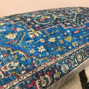 May include: A blue and red patterned throw pillow with a white border. The pillow has a traditional Persian rug design.