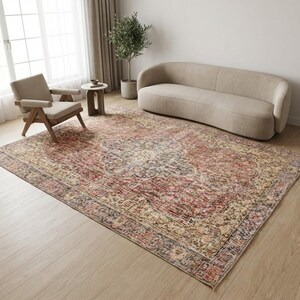 May include: A large rectangular area rug featuring a distressed pattern in shades of terracotta, cream, sage green, and navy blue. The rug has a central medallion design surrounded by an intricate floral border, covering the floor in a living room.