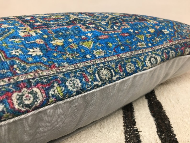 May include: A blue and white patterned throw pillow with a gray border. The pillow is made of a soft, plush fabric and has a subtle sheen.