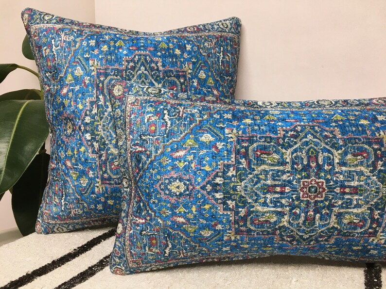 May include: Two decorative throw pillows with a blue and white patterned design. The pillows have a geometric pattern with a central medallion.
