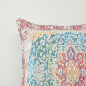 May include: A colorful throw pillow with a patterned design featuring shades of blue, green, red, yellow, and white.