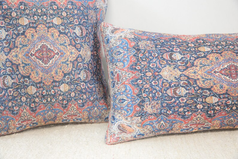 May include: Two decorative throw pillows with a blue, red, and yellow paisley pattern.