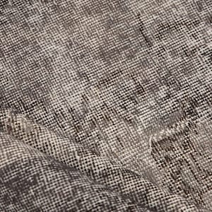 May include: Close-up of a gray and white woven rug with a textured surface.