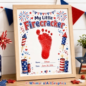 May include: A framed print featuring the text My Little Firecracker, a red footprint, and illustrations of fireworks and rockets in red, white, and blue. The print includes lines for the name Ethan and the date June 28, 2026, with red hearts and stars.