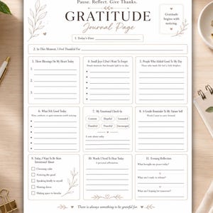 May include: A white gratitude journal page with black text and botanical line art. The layout includes sections for daily reflections, blessings, emotional check-ins, and affirmations, titled "Pause. Reflect. Give Thanks." and "GRATITUDE Journal Page."